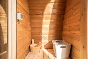 Elle comprend une petite salle de bains pourvue de toilettes et d'un mur en bois. dans l'établissement Tiny House Lachen, à Wangen im Allgäu