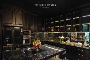 a kitchen with black cabinets and a granite counter top at The Black Kingdom - เดอะ แบล็ค คิงดอม in Bangkok