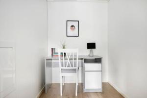 escritorio blanco con silla y ordenador en Moderne leilighet - nært flyplass - lader for elbil en Råholt