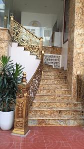 a set of stairs in a building with a gold railing at Thanh Tung Hotel in Ha Long