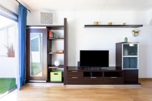 a living room with a television on a shelf at Home2Book Lovely Ocean Views Apt Tabaiba in Tabaiba