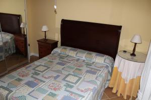 1 dormitorio con 1 cama con edredón en La Casita de Marina Golf-Costa Ballena, en Cádiz