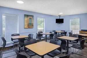 una classe con tavoli e sedie in una stanza con pareti blu di Days Inn by Wyndham Pensacola I-10 a Pensacola