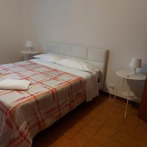 ein Schlafzimmer mit einem Bett mit einer Decke und einem Tisch in der Unterkunft Room Pappagnocca in Reggio nell'Emilia