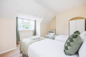 1 dormitorio con 2 camas y ventana en Newly Launched 2 Bed Home in Dagenham ~London with free Wifi & Off-Street Parking, en Goodmayes