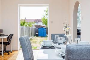 a dining room with a glass table and chairs at Newly Launched 2 Bed Home in Dagenham ~London with free Wifi & Off-Street Parking in Goodmayes
