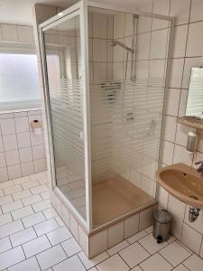 bagno con doccia in vetro e lavandino di Hotel Gasthof Altmann a Warzenried