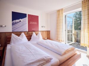 Un dormitorio con una cama grande y una ventana grande. en Hotel Pinzgauerhof by Alpeffect Hotels, en Zell am See
