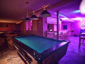 a pool table in a bar with purple lighting at Hotel Pinzgauerhof by Alpeffect Hotels in Zell am See