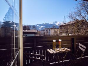 a table and chairs on a balcony with a view at Hotel Pinzgauerhof by Alpeffect Hotels in Zell am See