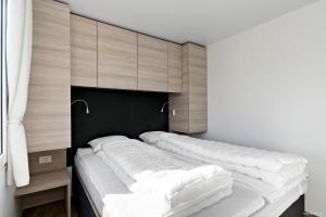 1 dormitorio con 1 cama grande con almohadas blancas en First Camp Röstånga-Söderåsen, en Röstånga