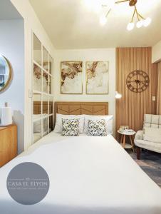 ein Schlafzimmer mit einem großen weißen Bett und einem Stuhl in der Unterkunft Wooden Aesthetic Fully Furnished Studio at INSPIRIA in Davao City