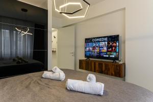 due asciugamani su un letto in una camera con televisore di Blue Moon Apartments a Braşov