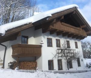 a house with a balcony in the snow at Auszeit im Chiemgau in Rottau