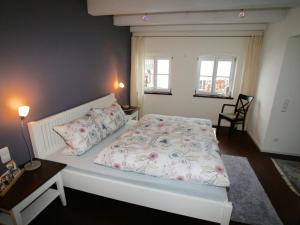 a bedroom with a bed and a table and two windows at Auszeit im Chiemgau in Rottau