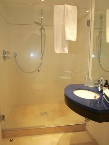 a bathroom with a sink and a glass shower at Auszeit im Chiemgau in Rottau