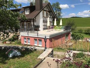 ein Haus mit einem Zaun davor in der Unterkunft Gästezimmer Grundmühle in Nordheim vor der Rhön