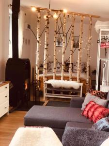 a living room with a couch and trees with lights at Larix Mátra Vendégház in Matraszentlaszlo