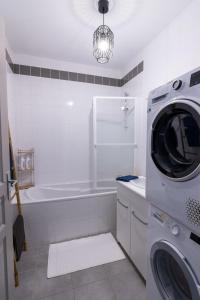 a bathroom with a washing machine and a tub at Superbe Appartement in Saumur +16 photos