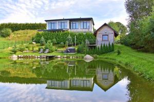 a house on a hill next to a body of water at MS Resort in Nemėžis