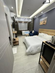 Habitación de hotel con cama y mesa con TV en Blue Rose Hotel en Al Amarat