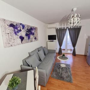 Sala de estar con sofá gris y mesa en Vila Kata en Zubovići