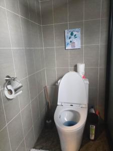 a bathroom with a toilet with the lid up at Portofino Homestay in Malitbog