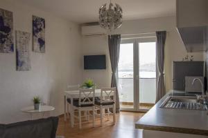 a kitchen and living room with a table and chairs and a dining room at Vila Kata in Zubovići