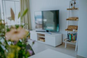 a living room with a tv and a white cabinet at Panorama Mar Apartment in Punta Prima