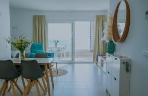 a dining room with a table and chairs and a mirror at Panorama Mar Apartment in Punta Prima