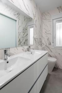 a white bathroom with a sink and a toilet at Puerta del Ángel, casa independiente, 3 plantas in Madrid