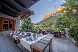 un patio con mesas y sillas con montañas en el fondo en Camping Seiser Alm, en Fiè