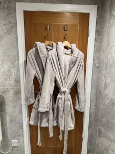 a robe hanging on a door in a bathroom at Brand New Listing - The Honey Pot in Stanton in Stanton