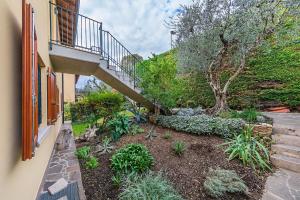 un jardín con una escalera junto a un edificio en Poggio Picedo P1-32 by Wonderful Italy, en Polpenazze del Garda