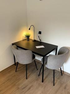 einem schwarzen Tisch mit zwei Stühlen und einer Lampe in der Unterkunft Comfortable Apartment in Weener