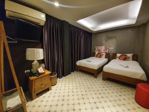 pokój hotelowy z 2 łóżkami i telewizorem w obiekcie Baan Wualamphong บ้านวัวลำพอง w mieście Bangkok