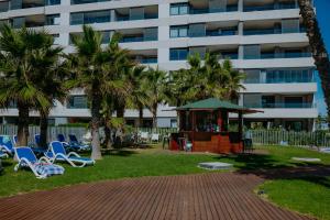 a park with chairs and a gazebo and a building at Panorama Mar Apartment in Punta Prima