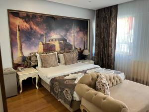 1 dormitorio con 1 cama grande y una pintura en la pared en Elite Marmara Bosphorus&Suites, en Estambul