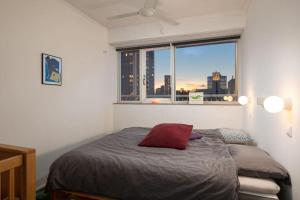 a bedroom with a bed and a window with a city skyline at Cozy Stay Rotterdam City in Rotterdam