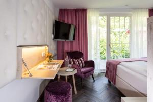 a hotel room with a bed and a desk and chair at Boutiquehotel Bergvilla in Dafins