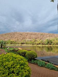 une masse d'eau avec une colline en arrière-plan dans l'établissement Bass Lake Country Lodge, à Pretoria