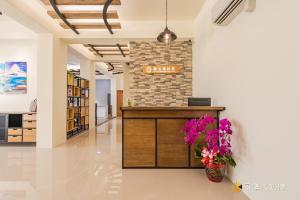 an office lobby with a reception desk and flowers at Tie Zhi Road B&B in Taitung City