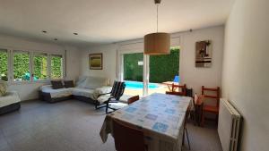 ein Wohnzimmer mit einem Tisch und einem Sofa in der Unterkunft Villa Pals Carles Piscina in Pals