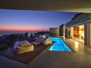 a villa with a swimming pool and a house at Santorini Heights in Pyrgos