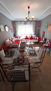 sala de estar con mesa, sillas y sofá en Chez Axia Tanger, en Tánger