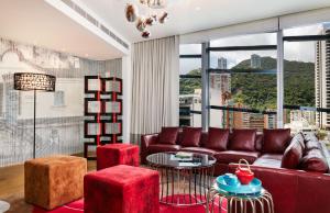 a living room with a red couch and a large window at Hotel Indigo Hong Kong Island, an IHG Hotel in Hong Kong