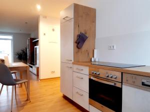 Il comprend une cuisine équipée d'un réfrigérateur blanc et d'une cuisinière. dans l'établissement STADTOASE geräumige Gästewohnungen mit Balkon, Komfort, Modernität und Ruhe, Für Monteure geeignet, Free WiFi, à Frankenberg