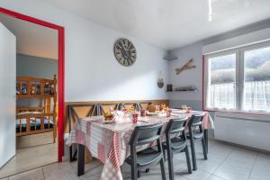 mesa de comedor con sillas y reloj en la pared en Le Célesthémy, en Cornimont