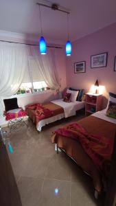 a bedroom with two beds and blue lights at Chez Axia Tanger in Tangier