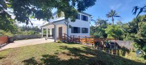 une maison blanche avec une clôture et une cour dans l'établissement La villa Tortue, meublé de tourisme 4 étoiles, à Le Tampon